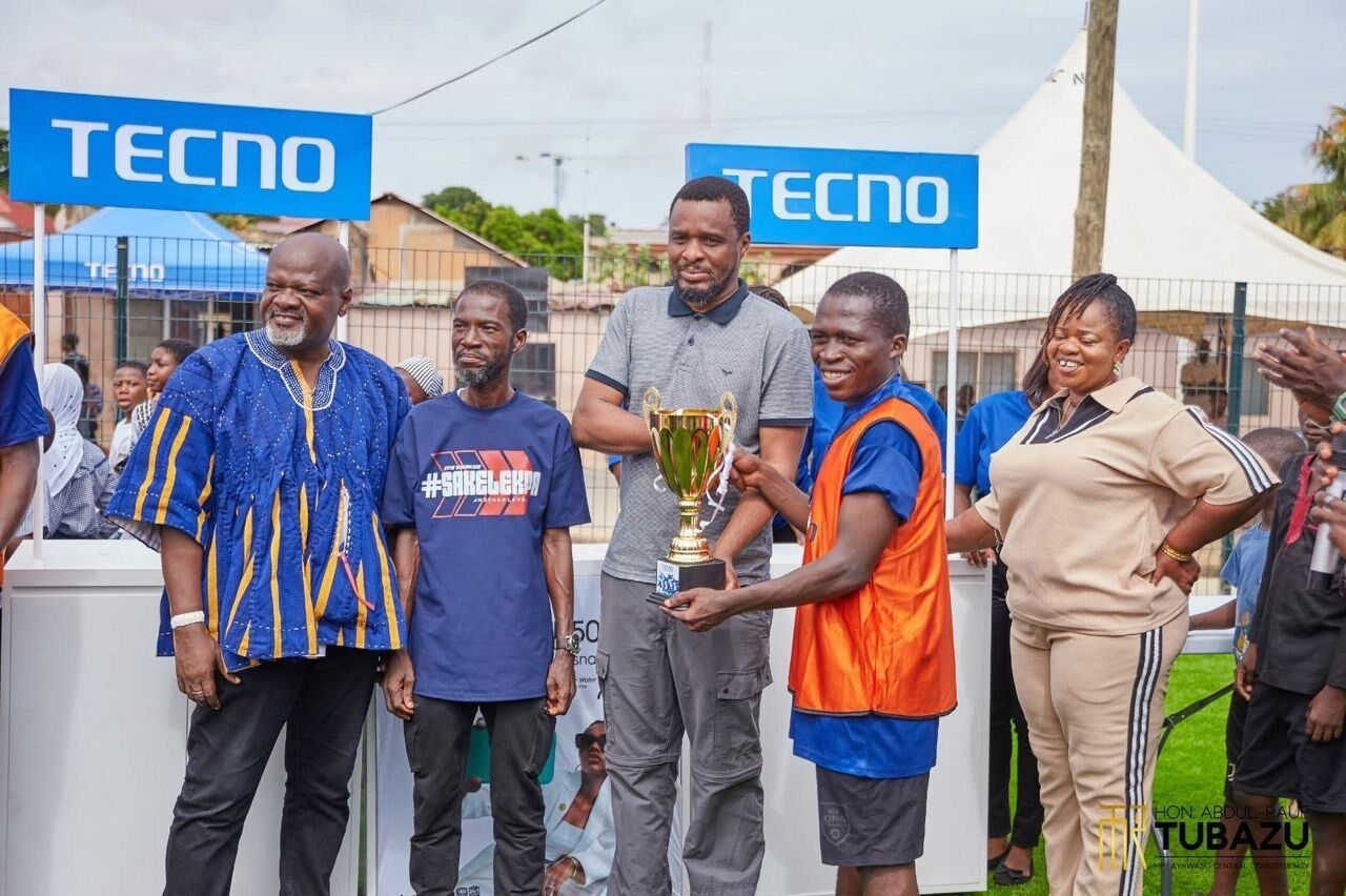 The MP presents the champion’s trophy at the commissioning tournament, with the MCE and officials