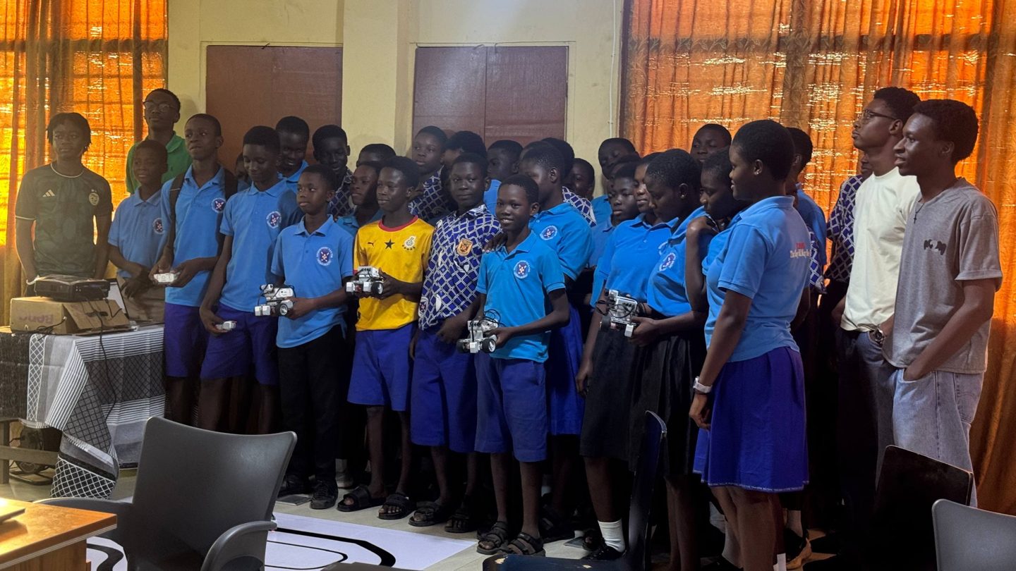 Students with the robots they built and programmed, alongside Mikrobot Academy trainers