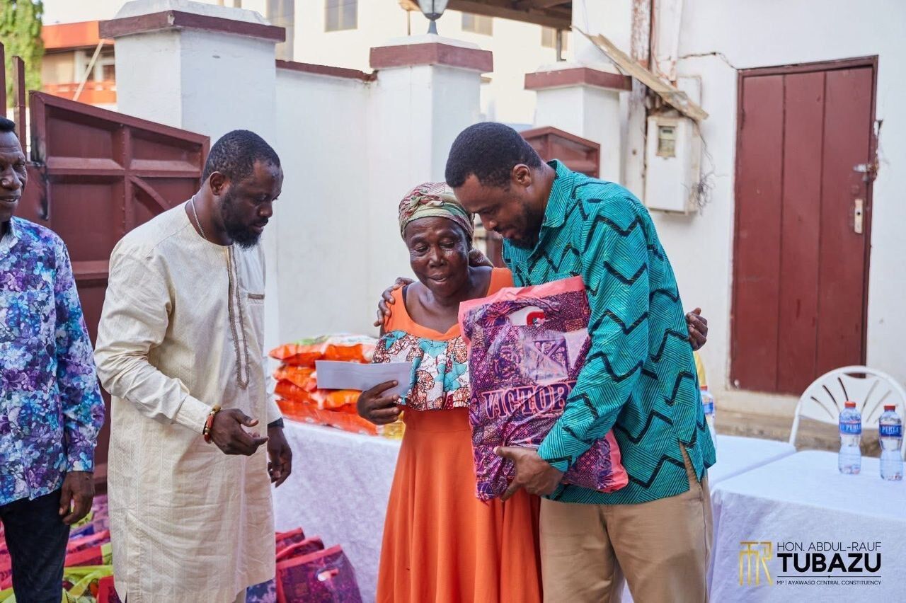 The MP presenting cloth and food items to a widow